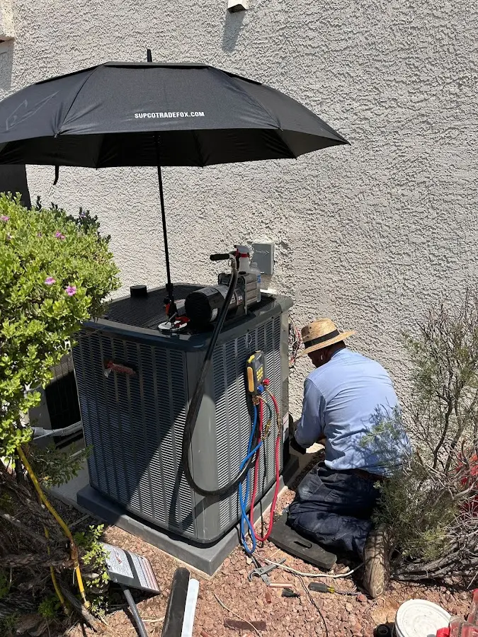HVAC technician performing outdoor AC maintenance in California City